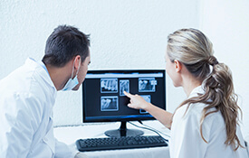 Dentists looking at dental x-rays on computer