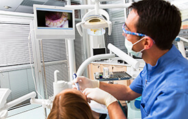 Dentist and patient examining smile photos on computer